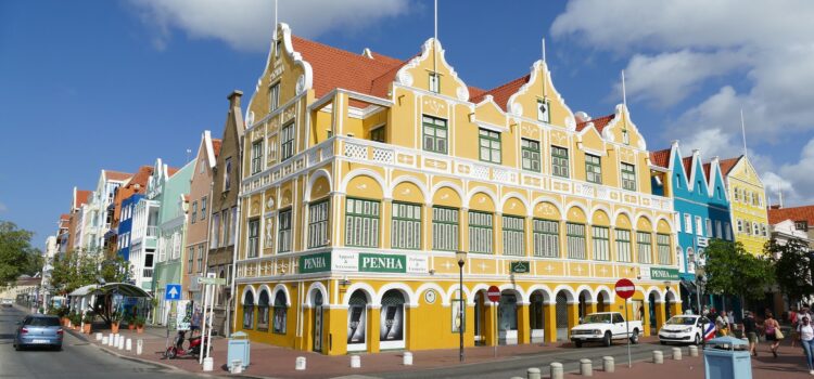 a yellow heritage building in curacao which is stunning to look at with red roof