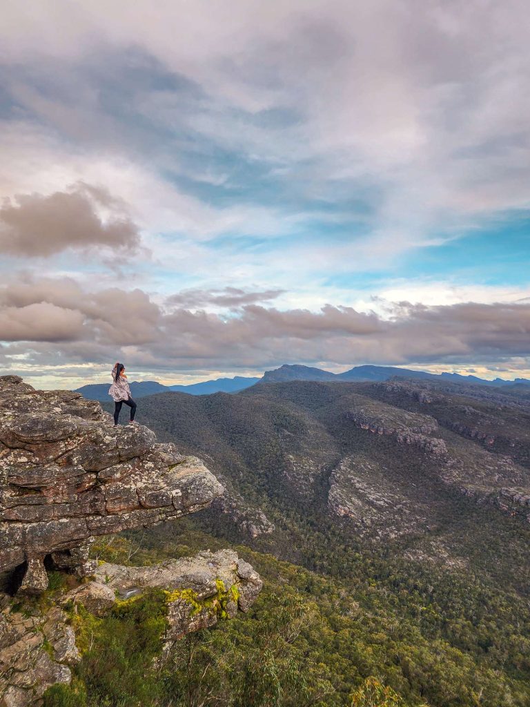 Melbourne to Grampians road trip - Australia, VIC, woman on rock formation in Grampians national park named The Balconies